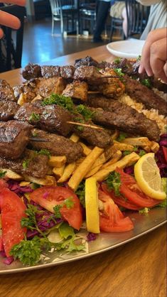 a platter full of meat and vegetables on a table