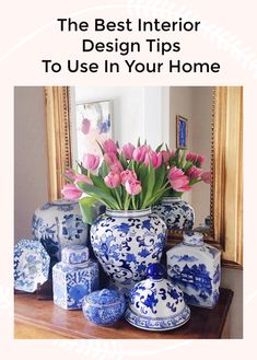 blue and white vases with pink tulips in them sitting on a table