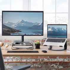 two computer monitors sitting on top of a wooden desk next to a keyboard and mouse