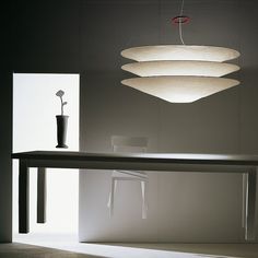 a table and chair in a room with lights hanging from it's ceiling above