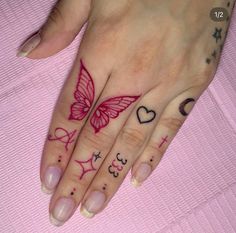 a woman's hand with tattoos on it and a butterfly tattooed on the ring finger