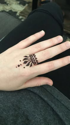 a woman's hand with a henna tattoo on her left wrist and fingers