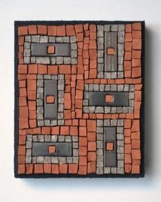 an orange and gray tile with black squares on it's sides, in the shape of rectangles