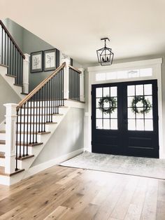 an empty entryway with two doors and some wreaths on the stairs