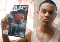 a young man holding up a magazine in front of his face