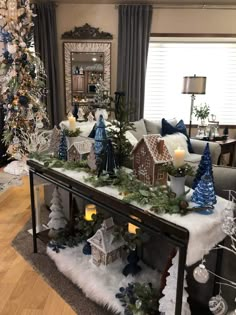 a living room decorated for christmas with decorations and candles on the table in front of it