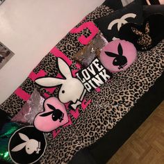 some pink and black pillows on a leopard print bed spread with the word love bunnies