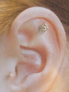 a woman's ear with three small flowers on it