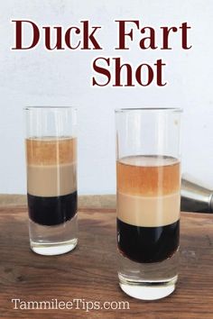 two shot glasses filled with liquid sitting on top of a wooden table next to the words duck fart shot