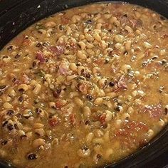 a black crock pot filled with beans and meat