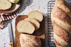 sliced bread sitting on top of a wooden cutting board next to a knife and bowl