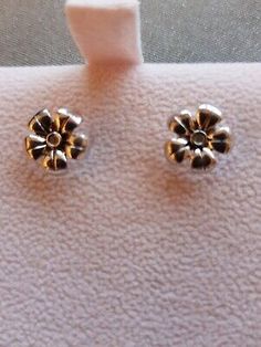 two small gold flower studs on a white surface