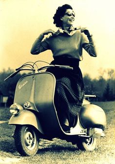 an old photo of a woman on a scooter