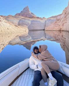 two people sitting on the back of a boat