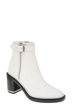 A buckle strap and ball studs at the welt lend moto edge to this block-heel bootie built for comfort with memory-foam cushioning and a breathable lining. 3 1/4" heel 5" shaft Side zip closure Memory foam cushioning Synthetic upper, lining and sole Imported White Leather Boots With Ankle Strap, Spring High Ankle Moto Boots With Buckle Closure, Fabric Gift Bags, Nordstrom Store, Anniversary Sale, Boot Shoes Women, Memory Foam, Block Heels, Buckle