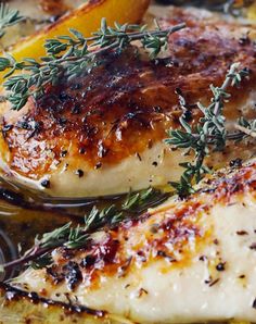 grilled chicken with lemons and herbs in a pan