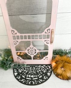 a pink front door with an iron screen