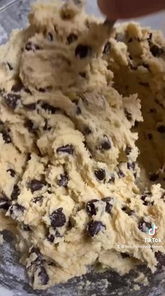 a mixing bowl filled with batter and chocolate chip cookie dough, ready to be mixed together