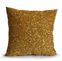 a gold pillow on a white background with lots of small glitters in the middle