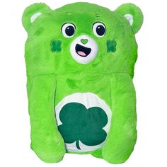 a green teddy bear with four leaf clover on it's chest and eyes open