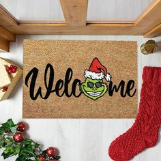 a door mat with the words welcome and an image of a frog wearing a santa hat