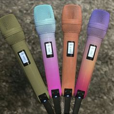 four different colored microphones sitting in a row on top of each other's heads