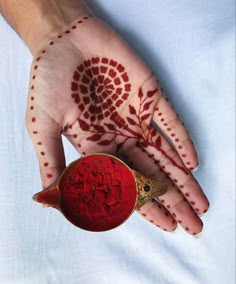 a person's hand with red henna on it