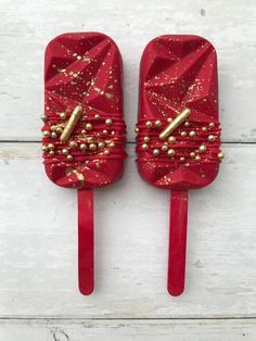 two red pops with gold decorations on them