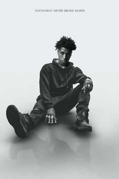 a man sitting on the ground in front of a white background with text that reads, youngboy never broke again