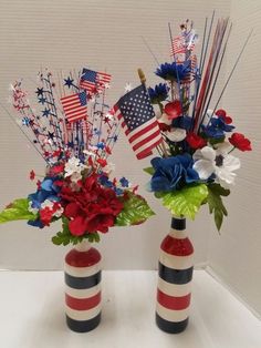 two red, white and blue vases with flowers in them