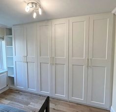 an empty bedroom with white closets and wood flooring