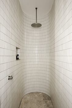 a white tiled bathroom with a shower head