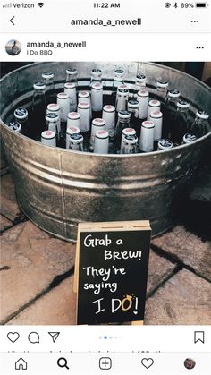 a bucket full of beer bottles sitting on top of a floor next to a sign that says grab a brew they're saying i do