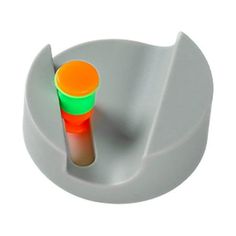 an orange and green cup sitting on top of a white holder