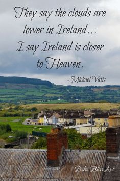 there are clouds in the sky above some roofs and buildings with a quote on it