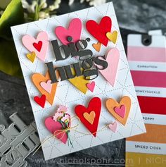 a close up of a greeting card with hearts on it and flowers in the background