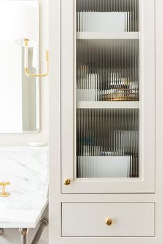 a white cabinet sitting next to a marble counter top