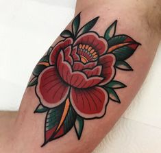 a red flower with green leaves on the leg