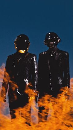 two mannequins dressed in shiny black suits and gold helmets are standing next to each other