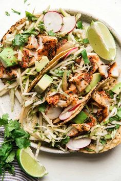 chicken tacos with avocado, radishes and cilantro on a plate