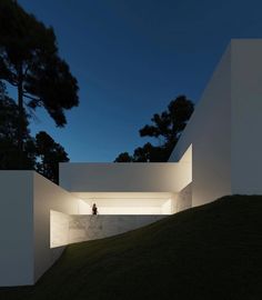 an image of a person standing in the dark outside at night with light coming from their windows