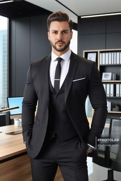 a man in a black suit and tie posing for a photo with his hands on his hips