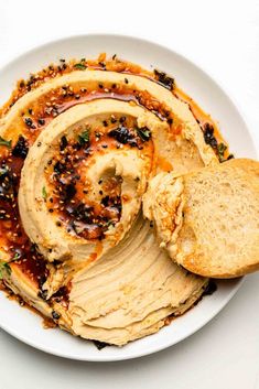 a white plate topped with hummus and bread