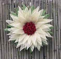 a white and red flower on top of a wooden fence