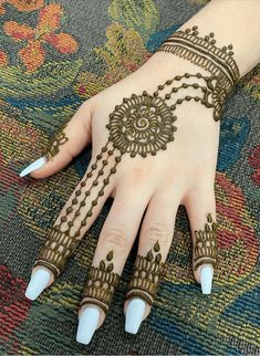 a woman's hand with henna tattoos on it