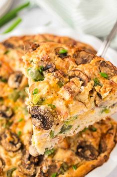 a close up of a slice of pizza on a plate with green onions and mushrooms