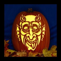 a carved pumpkin with an image of a demon's head on it, surrounded by leaves