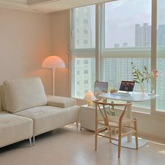 a living room filled with furniture and a laptop computer on top of a wooden table