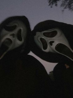 two people wearing masks in the dark