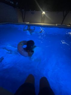 two people are in the pool at night